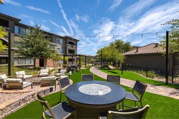 A patio with a table and chairs is surrounded by buildings.